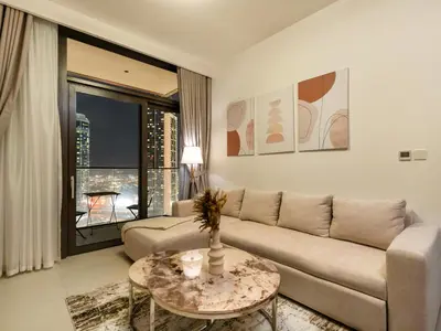 a living room with a couch and a table at Modern 1BR in DOWNTOWN I Near DUBAI MALL & FOUNTAIN in Dubai