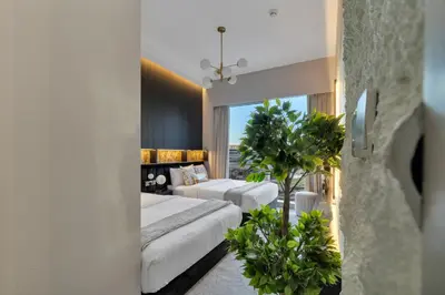 a hotel room with two beds and a palm tree at Gogoto2 Lux Burj Khalifa View 5 min Dubai Mall PS5 NYE Fireworks View in Dubai