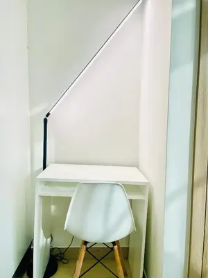 a white desk with a white chair and a lamp at Azizi Rivieira Meydan, Dubai Luxury Studio with Burjkhalifa and Pool views in Dubai