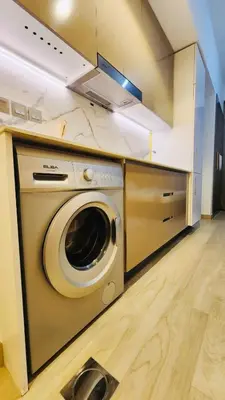 a kitchen with a washing machine in a kitchen at Azizi Rivieira Meydan, Dubai Luxury Studio with Burjkhalifa and Pool views in Dubai