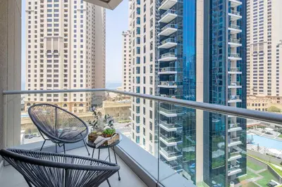 a balcony with two chairs and a view of a city at Frank Porter - Beauport Tower in Dubai