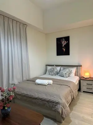 a bedroom with a large bed with a window at Azizi riviera luxury studio apartment monthly rent in Dubai