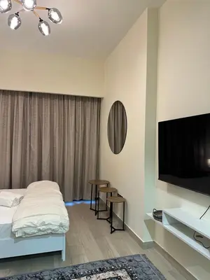 a hotel room with a bed and a flat screen tv at Azizi riviera luxury studio apartment monthly rent in Dubai