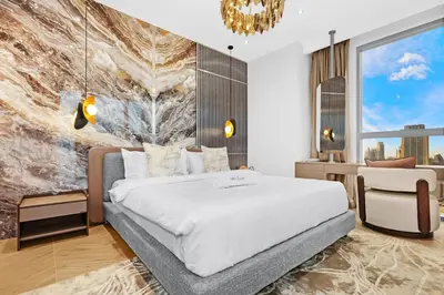 a bedroom with a large bed and a chandelier at FIRST CLASS 4BR Burj Khalifa & Fountain View in Dubai