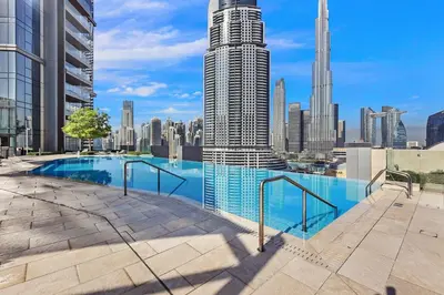 a swimming pool with a city skyline in the background at FIRST CLASS 4BR Burj Khalifa & Fountain View in Dubai