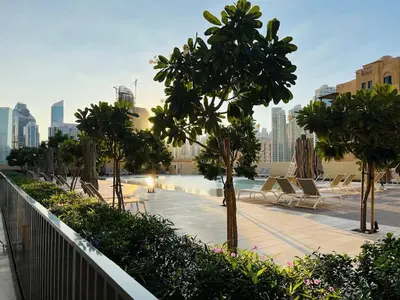 a swimming pool with chairs and trees in a city at Walk to Dubai Mall- Enjoy Burj Khalifa Show in Dubai