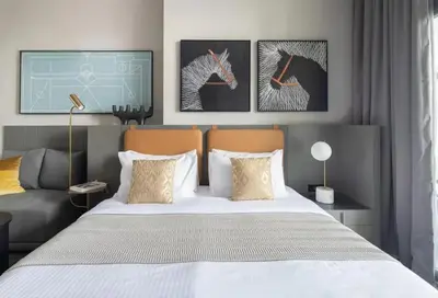 a bedroom with a bed and two paintings on the wall at CAICAI Homes Mag 318 Dubai Walking Distance to Dubai Mall in Dubai