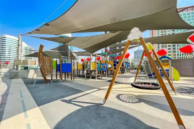 a playground with awning and play equipment in a city at CAICAI Homes Mag 318 Dubai Walking Distance to Dubai Mall in Dubai
