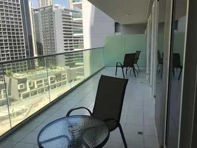 a chair on a balcony with a view of a city at 2 bhk 3 mins in down town in Dubai