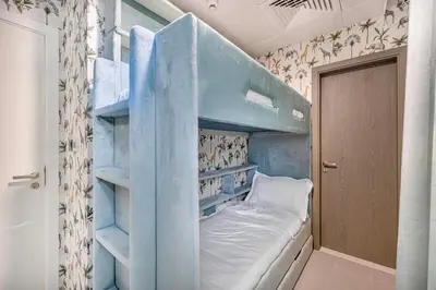 a blue bunk bed in a small room at Luxury 2 Bedroom plus kids room Burj Khalifa View in Dubai
