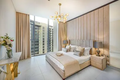a bedroom with a large bed and a chandelier at Luxury 2 Bedroom plus kids room Burj Khalifa View in Dubai