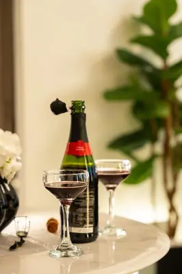 a bottle and two glasses on a table at Stylish Retreat - Embrace the Comfort in Dubai