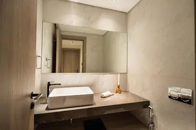 a bathroom with a sink and a large mirror at Stylish Retreat - Embrace the Comfort in Dubai