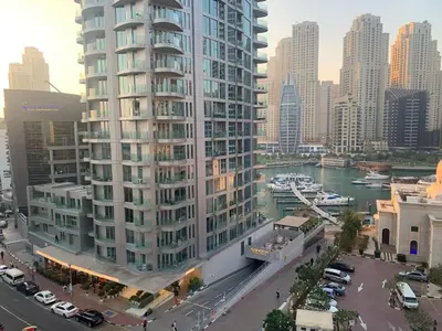 a tall building in a city next to a river at Dubai Marina-short stay in Dubai