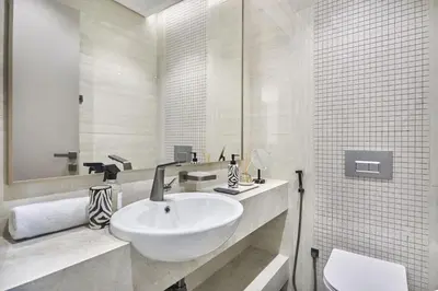 a white bathroom with a sink and a mirror at Stylish 2BRUrban Retreat 10 Min to Burj Khalifa in Dubai