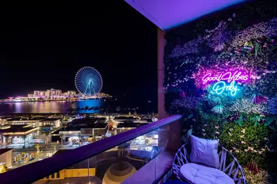 a balcony with a sign that reads cocacola club at night at Dubai Eye and Sunset Views 1 Bedroom Apartment with Direct Beach Access, Gym, and Pool in Dubai