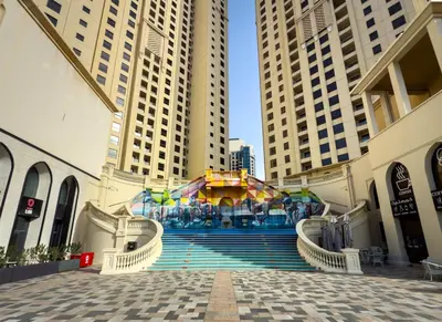 a group of tall buildings with a fountain in the middle at Dubai Eye and Sunset Views 1 Bedroom Apartment with Direct Beach Access, Gym, and Pool in Dubai