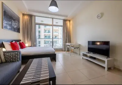 a living room with a bed and a tv at Well located Studio on 9 floor Sky View Tower in Dubai