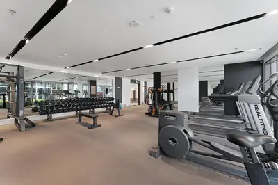 a gym with rows of treadmills and machines at Amazing 1BR Apt in Business Bay - Nobles Tower - Close to Dubai Mall in Dubai