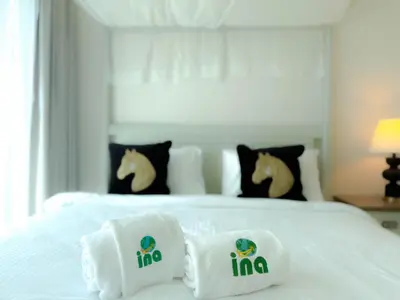 a white bed with white pillows on top of it at INA HOMES - Burj Royal 1 BR Stylish Apartment in Dubai