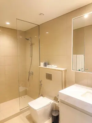 a bathroom with a shower and a toilet and a sink at INA HOMES - Burj Royal 1 BR Stylish Apartment in Dubai