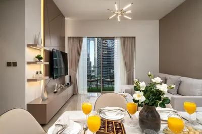 a living room with a table with a vase of flowers at Luxe Living at Grande Signature - Burj Khalifa and Sea Views - Brand New in Dubai