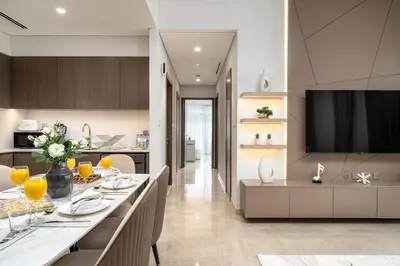 a kitchen and living room with a dining table and a television at Luxe Living at Grande Signature - Burj Khalifa and Sea Views - Brand New in Dubai