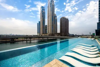 a swimming pool in a city with tall buildings at Sunset serenity - Urban Oasis Business Bay in Dubai