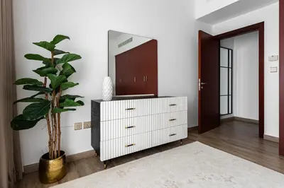a living room with a dresser and a mirror at 1 bedroom Apartment in JBR in Dubai