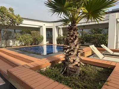 a house with a palm tree and a swimming pool at ASHRI Stylish African-Inspired Studio in DIFC in Dubai