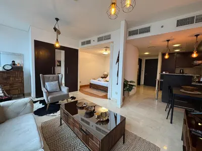 a living room with a couch and a table at ASHRI Stylish African-Inspired Studio in DIFC in Dubai