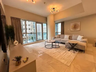 a living room with a couch and a large window at Spacious 1BHK Apartment, Near City centre in Dubai