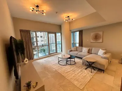 a living room with a couch and a large window at Spacious 1BHK Apartment, Near City centre in Dubai