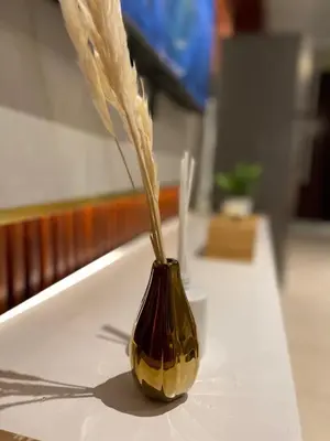 a vase with feathers in it sitting on a table at Ultra Luxury Chic Studio in JLT in Dubai
