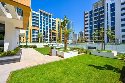a courtyard in a building with grass and buildings at Cozy Studio with Balcony in Azizi Riviera and 10 Mins to Burj Khalifa in Dubai