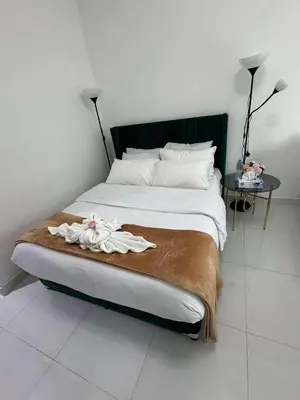 a bedroom with a bed with a black headboard and a table at Dubai Silicon Oasis Holiday Homes in Dubai