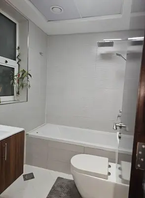a bathroom with a tub and a toilet and a sink at Dubai Silicon Oasis Holiday Homes in Dubai