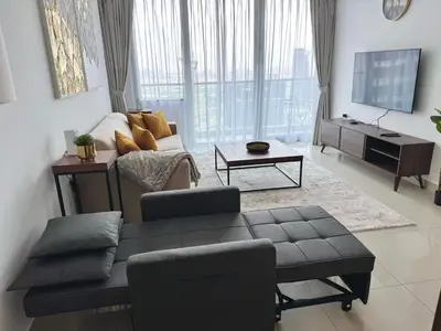 a living room with a couch and a tv at Elegant 1BR in Ocean Heights in Dubai