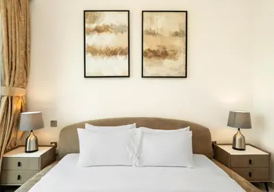 a bedroom with a bed with three pictures on the wall at Luxury 3 BR Full Burj Khalifa and Fountain View in Dubai