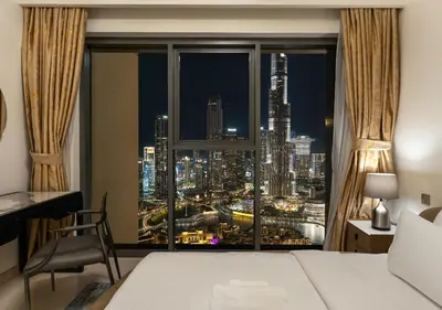 a bedroom with a window with a view of a city at Luxury 3 BR Full Burj Khalifa and Fountain View in Dubai