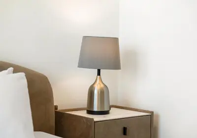 a lamp on a night stand next to a bed at Luxury 3 BR Full Burj Khalifa and Fountain View in Dubai