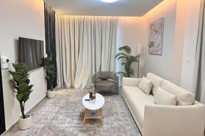 a living room with a white couch and a table at Vserve Modern Oasis Canal & Burj Views in Dubai
