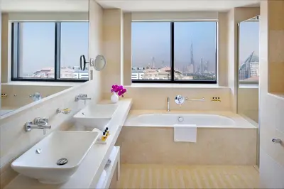 a bathroom with two sinks and a tub with windows at Hyatt Regency Creek Heights Residences in Dubai