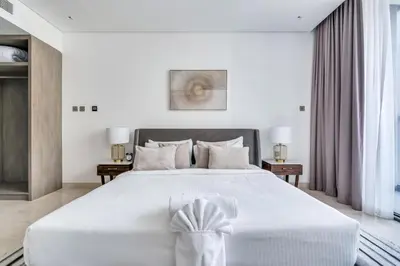 a white bedroom with a large white bed and curtains at New Luxury 1BR Apart Business Bay with Balcony in Dubai