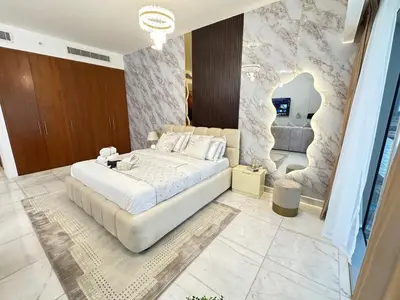 a bedroom with a large white bed and a couch at Central Park towers Difc suite kings in Dubai