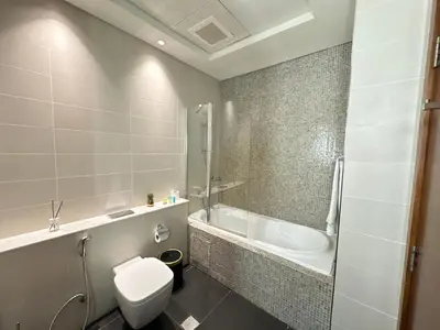 a bathroom with a toilet and a tub and a sink at Central Park towers Difc suite kings in Dubai