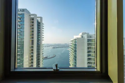 a window with a view of the ocean and buildings at Marina Vista - Elegant 1BR- 2606 in Dubai