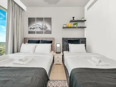 two twin beds in a room with a window at Downtown views II in Dubai