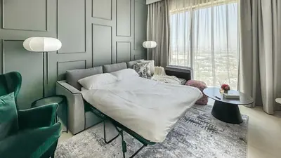 a bedroom with a bed and a couch and a table at Downtown views II in Dubai