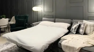 a bed with white sheets and pillows on a couch at Downtown views II in Dubai